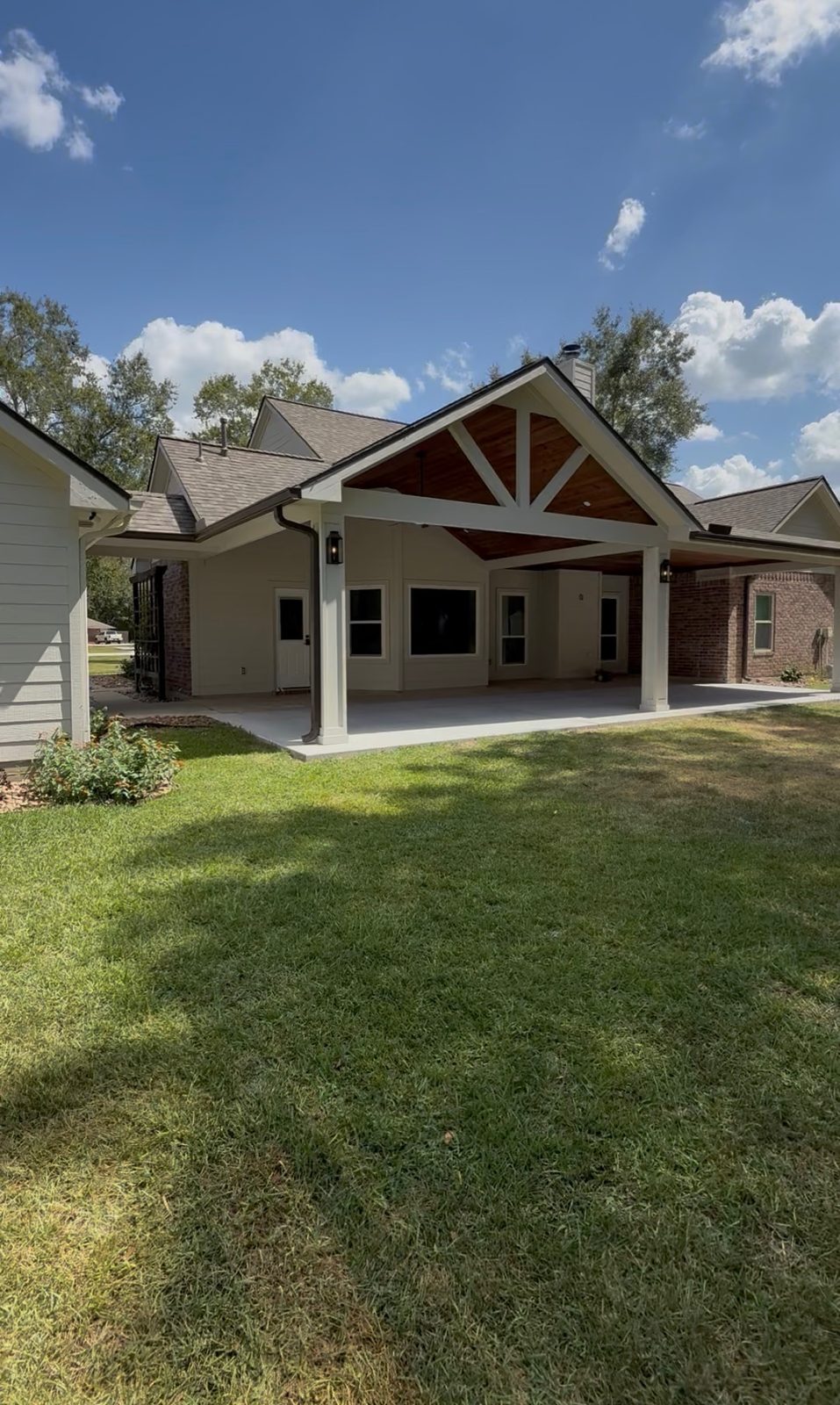 Custom gable patio cover with wood beam ceiling, daytime view